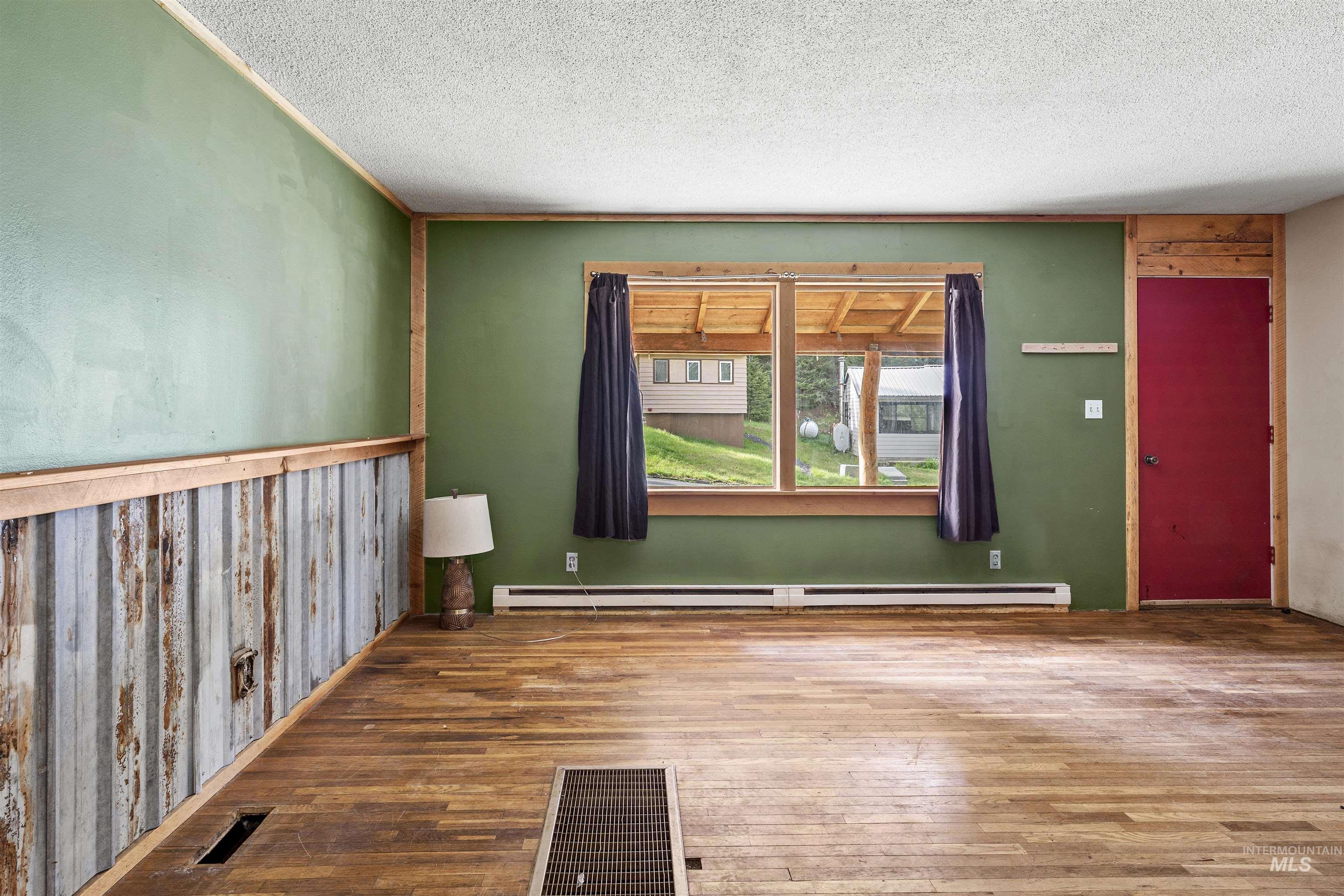 145 Timberline Drive Pierce, ID 83546 - Photo 12 of 39 Hardwood-finish flooring extending throughout, complemented by green painted walls and a corrugated metal wainscoting accent
