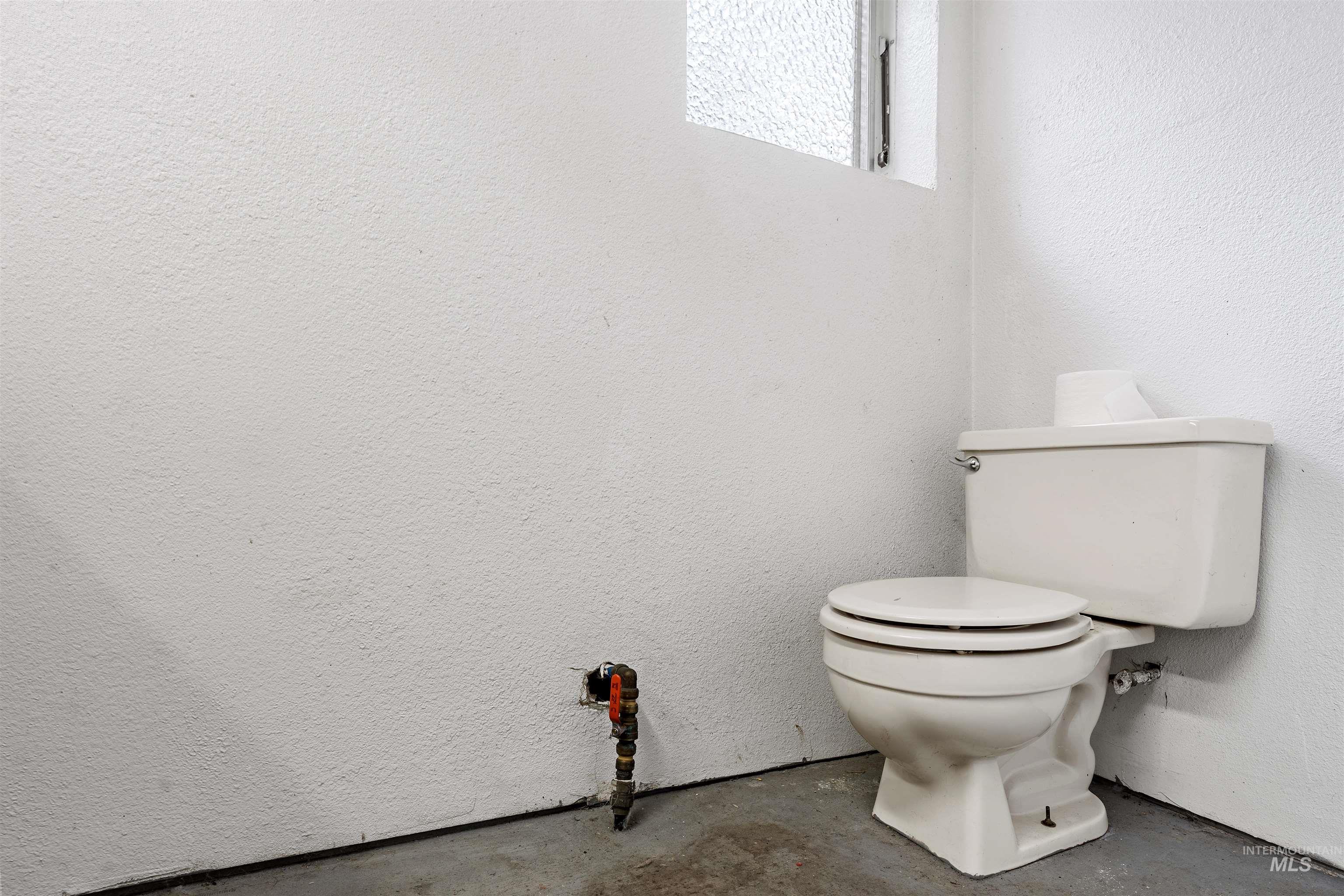 145 Timberline Drive Pierce, ID 83546 - Photo 15 of 39 White commode with exposed plumbing and a textured white wall