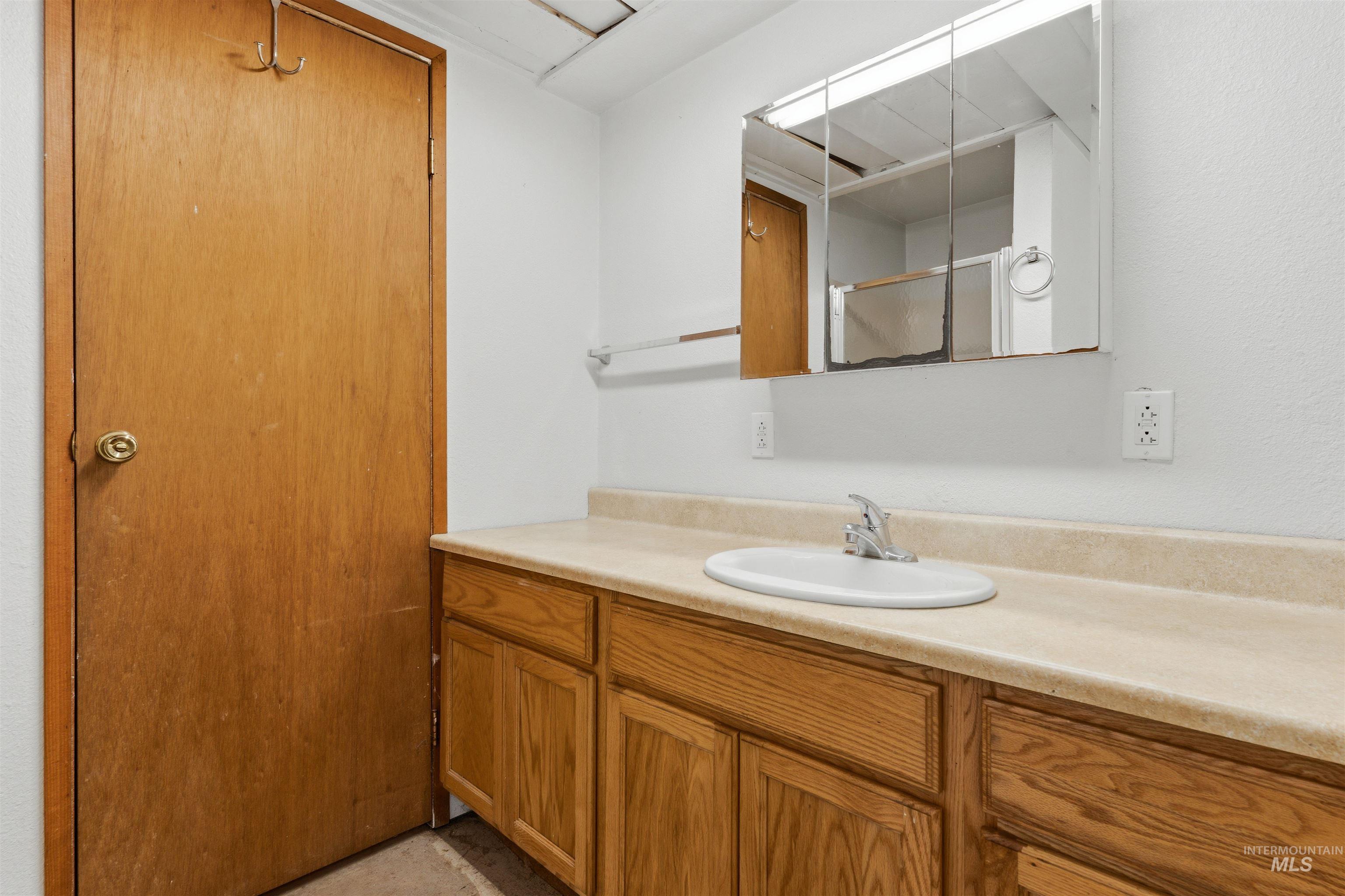 145 Timberline Drive Pierce, ID 83546 - Photo 17 of 39 Bathroom vanity featuring a light-toned countertop with an integrated sink and a chrome faucet