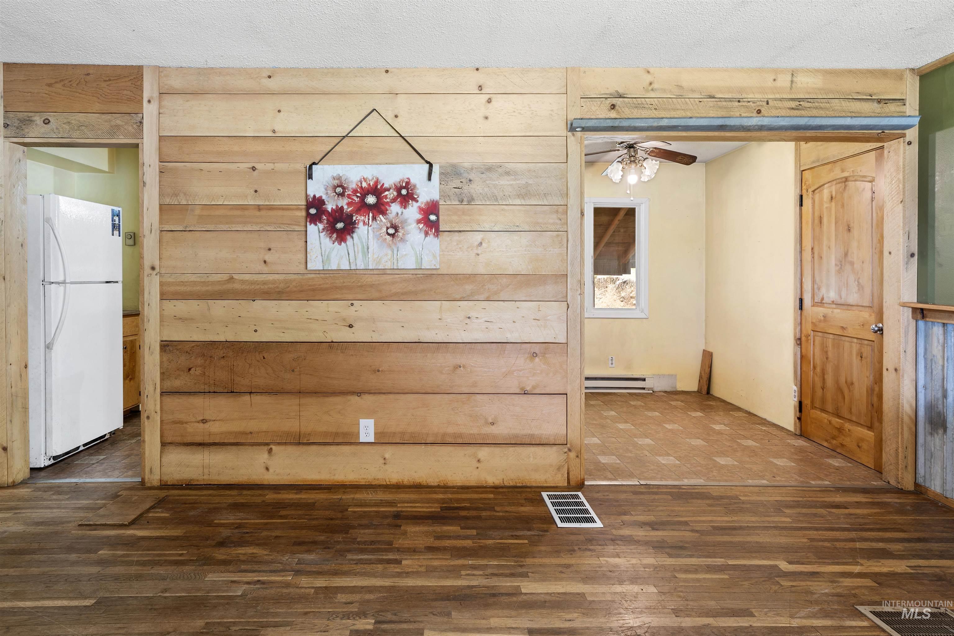 145 Timberline Drive Pierce, ID 83546 - Photo 28 of 39 Wood-finish flooring throughout, complemented by a wood-paneled accent wall and natural wood doors