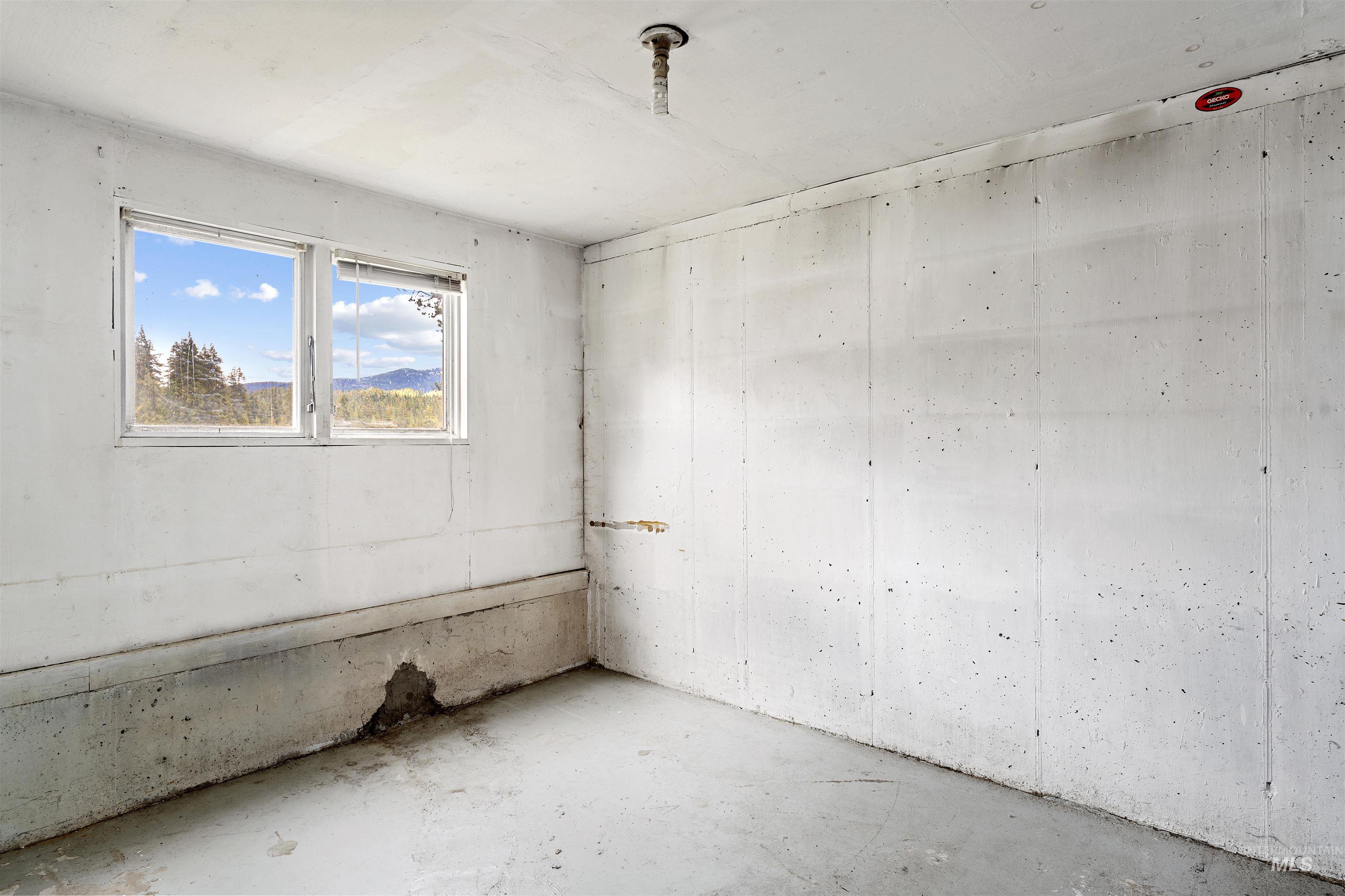 145 Timberline Drive Pierce, ID 83546 - Photo 30 of 39 Concrete interior walls and flooring in a room featuring a double-pane window