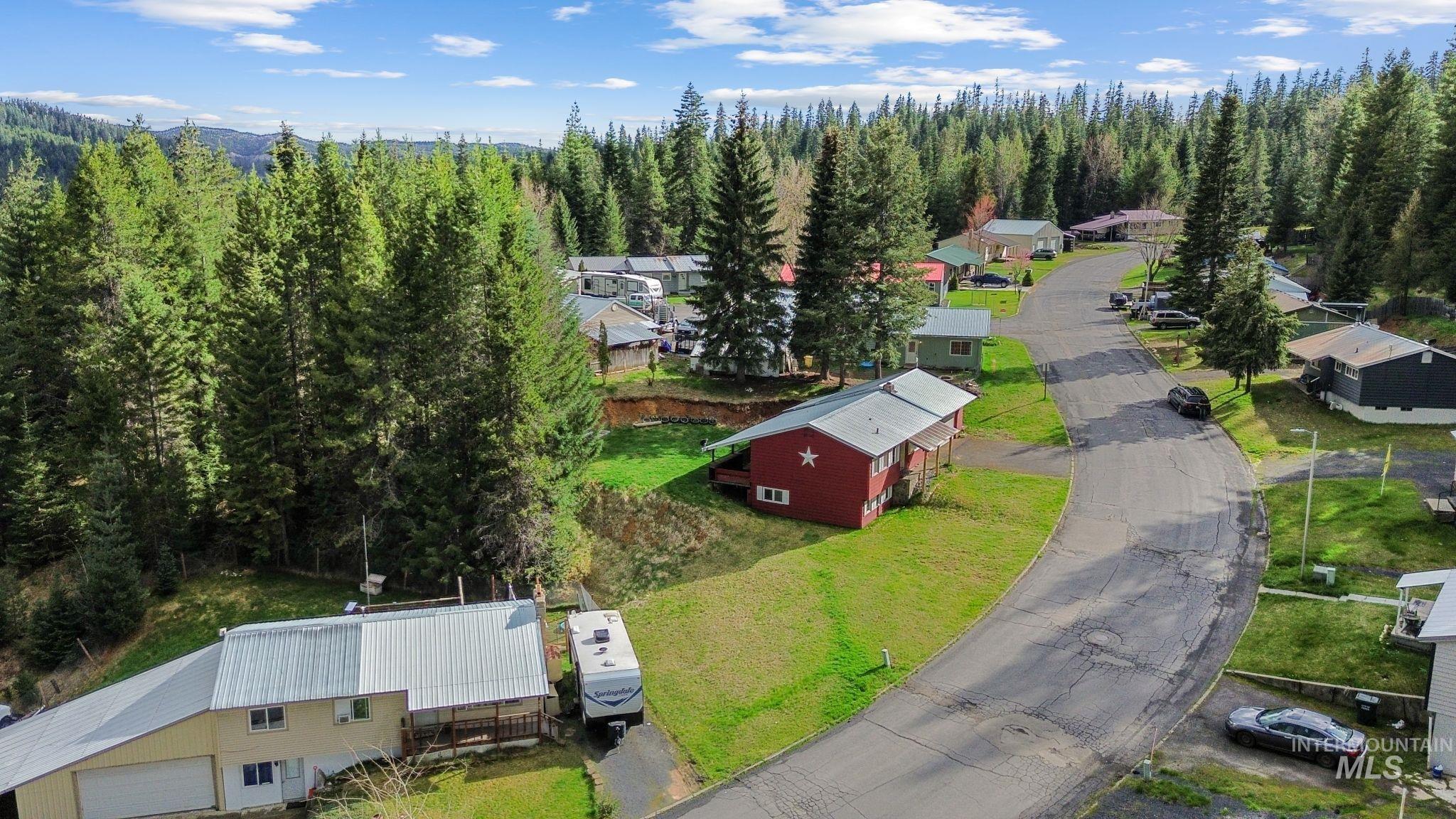 145 Timberline Drive Pierce, ID 83546 - Photo 3 of 39 Red siding residence with a metal roof and a prominent white star accent