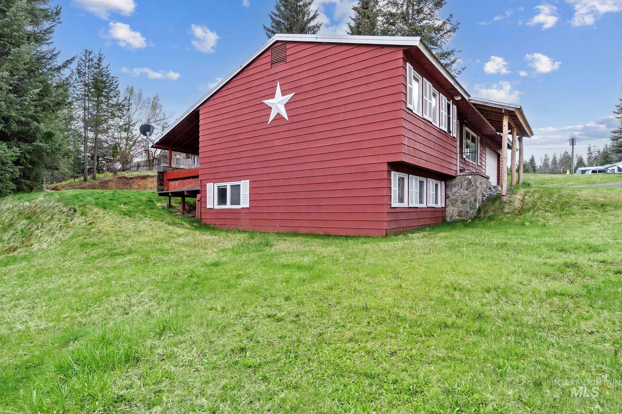 145 Timberline Drive Pierce, ID 83546 - Photo 37 of 39 Red siding exterior with white trim windows and a decorative star accent