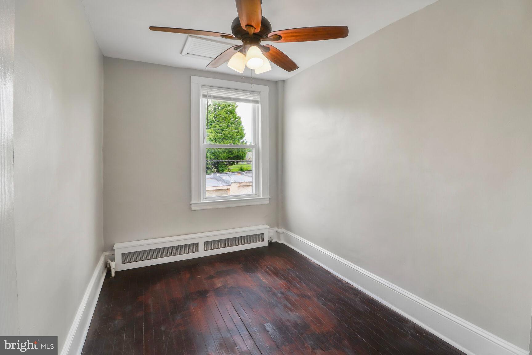 4122 Eierman Avenue Baltimore, MD 21206 - Photo 5 of 13 an empty room with a window and wooden floor