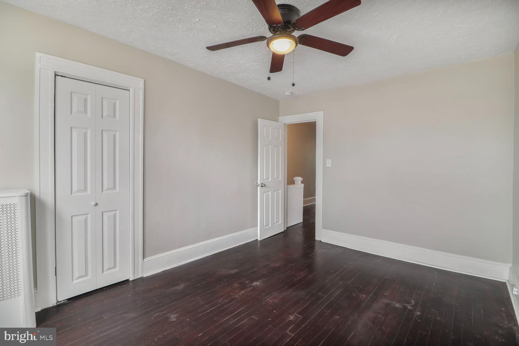 4122 Eierman Avenue Baltimore, MD 21206 - Photo 7 of 13 an empty room with wooden floor fan and windows