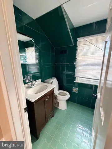 a bathroom with a sink toilet and window