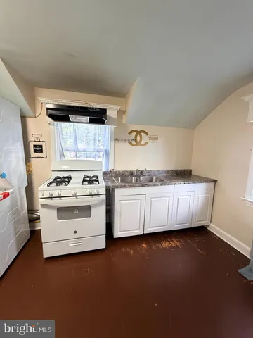 a kitchen with stainless steel appliances a stove and white cabinets