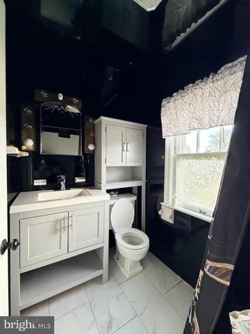 a bathroom with a toilet sink and mirror