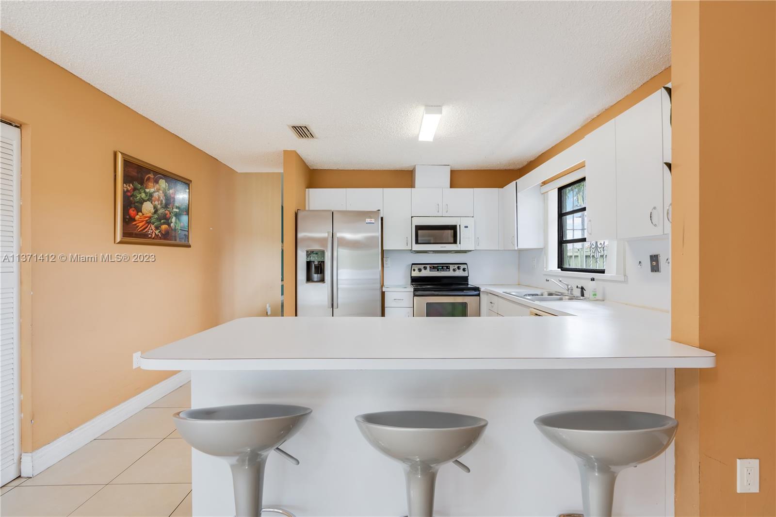 13817 Southwest 21st Terrace Miami, FL 33175 - Photo 15 of 37 a kitchen with stainless steel appliances a sink and a refrigerator