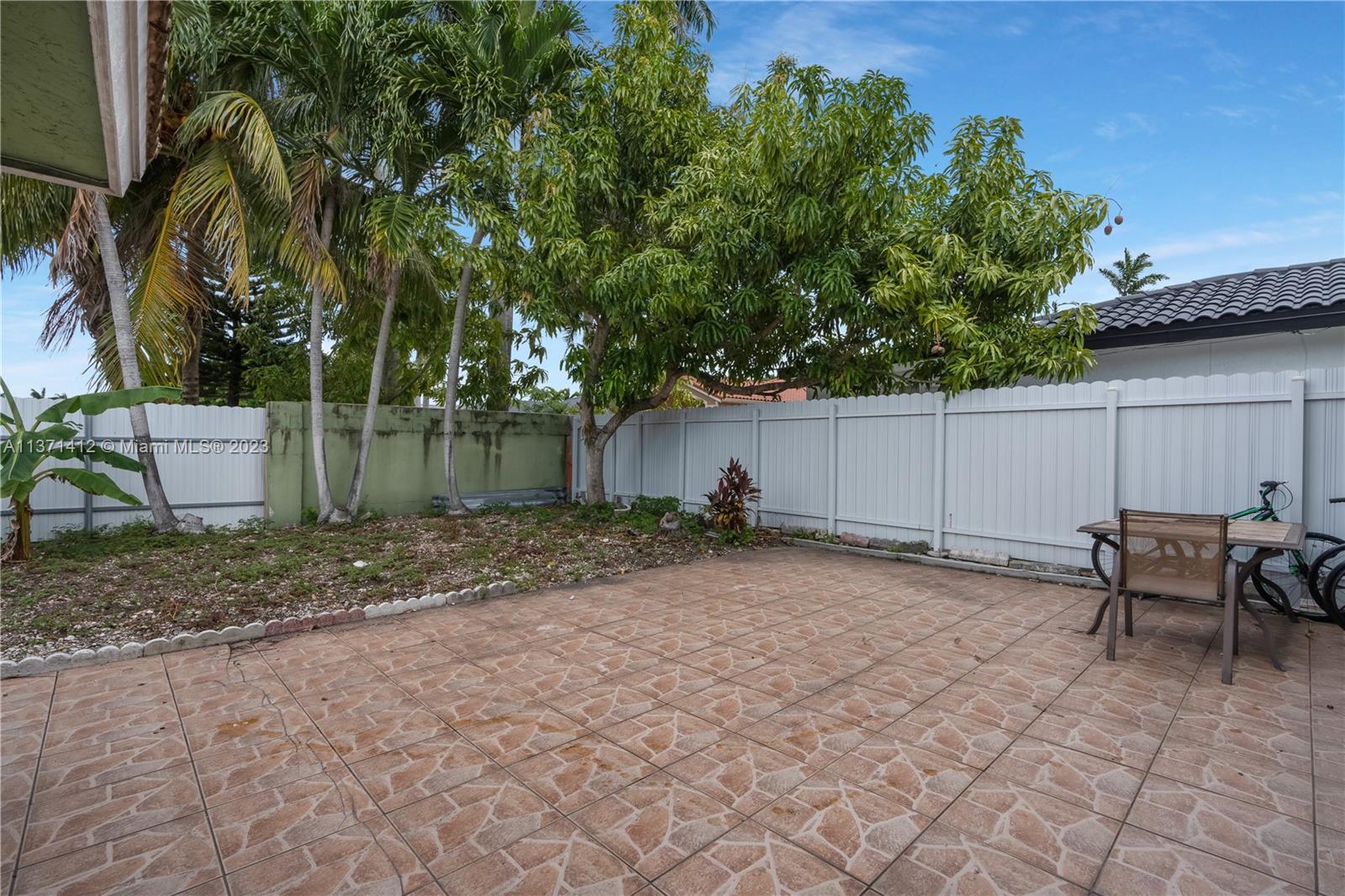 13817 Southwest 21st Terrace Miami, FL 33175 - Photo 32 of 37 a backyard of a house with table and chairs