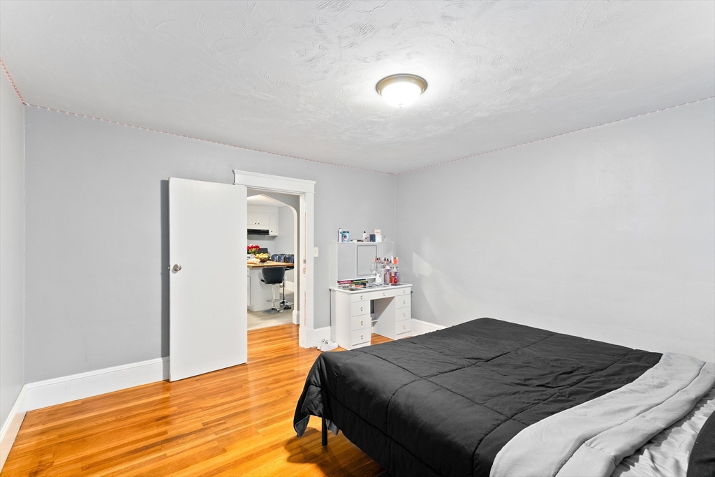 1039 South Main Street Fall River, MA 02724 - Photo 11 of 39 a bedroom with a bed and a wooden floor