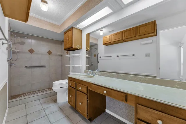a bathroom with a granite countertop sink a toilet a mirror and shower
