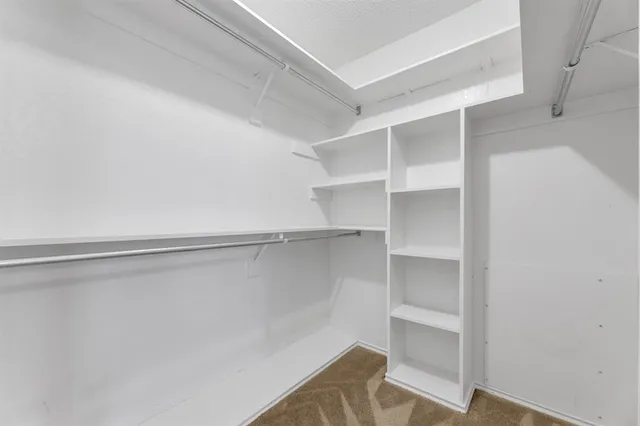 a view of walk in closet with empty racks