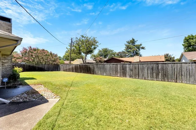 a view of backyard with wooden fence