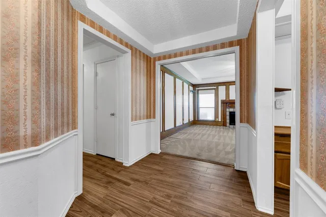 a view of a hallway with wooden floor and staircase