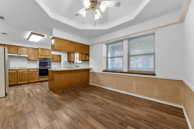 a kitchen with stainless steel appliances granite countertop a sink cabinets and wooden floor