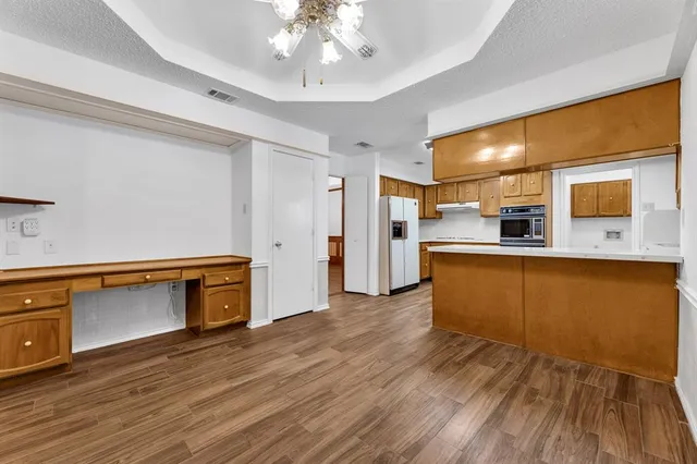 a kitchen with stainless steel appliances granite countertop a sink cabinets and wooden floor