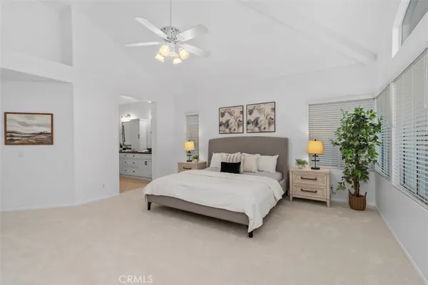 a spacious bedroom with a bed and a chandelier