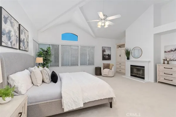 a bedroom with a bed potted plant and fireplace
