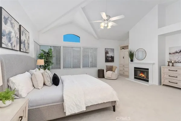 a bedroom with a bed large window and fireplace