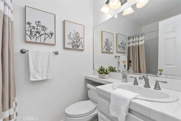 a bathroom with a granite countertop sink mirror vanity and toilet