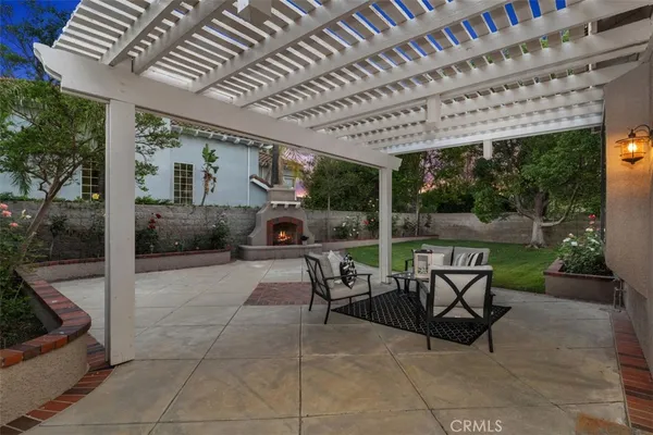 a patio with table and chairs and potted plants