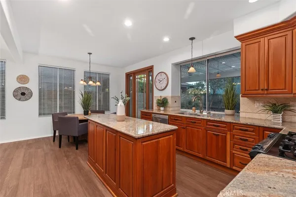 a kitchen with stainless steel appliances granite countertop a sink stove and wooden cabinets