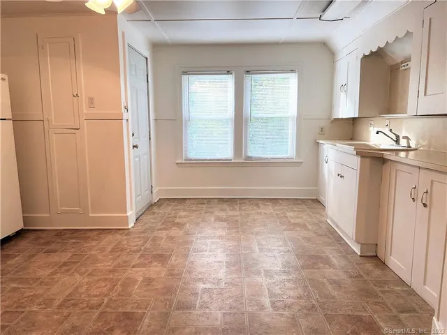 a view of a kitchen with a sink and dishwasher with wooden floor