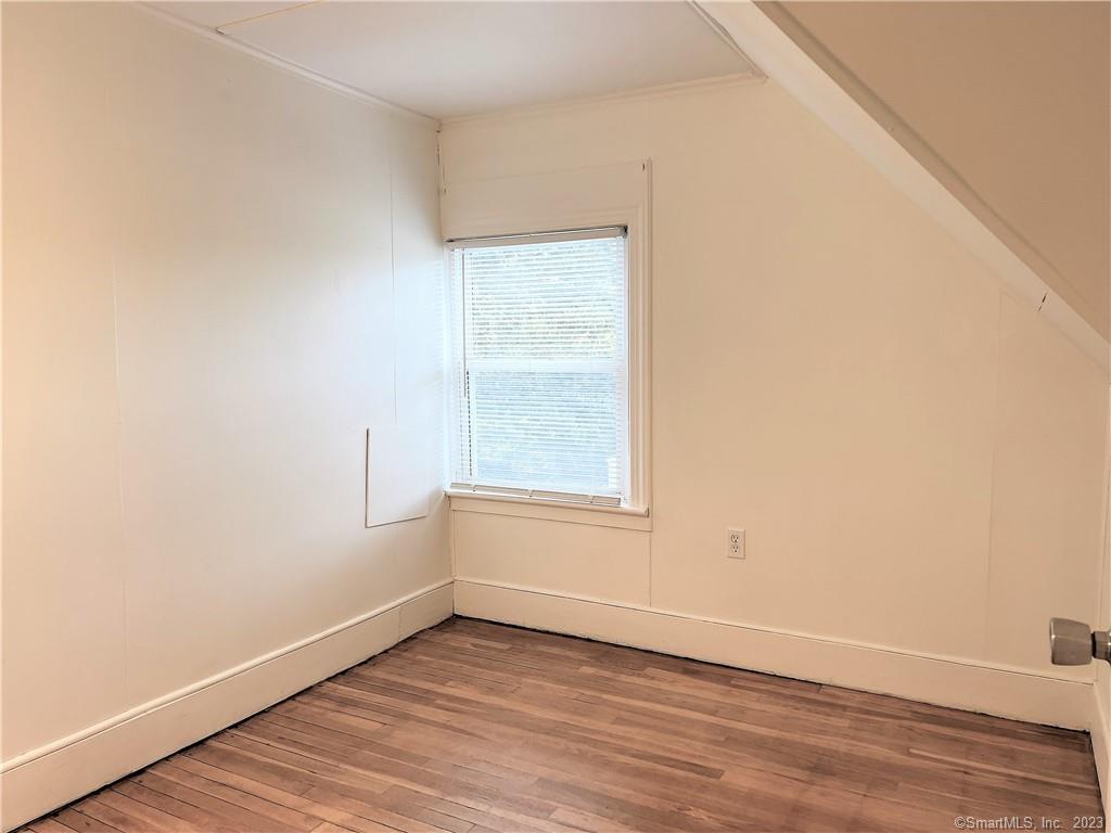 122 Derby Avenue, Unit 3 Seymour, CT 06483 - Photo 5 of 8 an empty room with wooden floor and windows