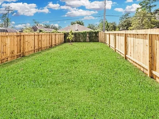 a view of a backyard with wooden fence
