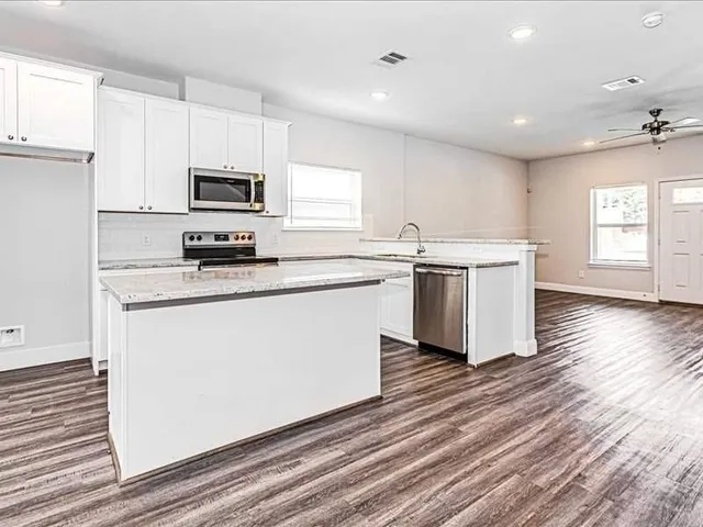 a kitchen with stainless steel appliances a white stove top oven sink and cabinets
