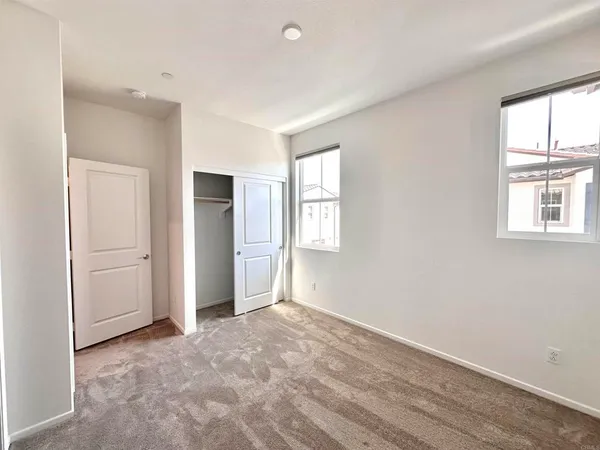 an empty room with windows and closet