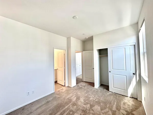 an empty room with closet and windows