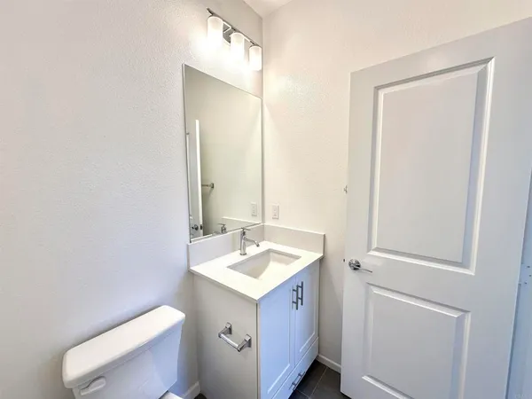 a bathroom with a sink a toilet and mirror