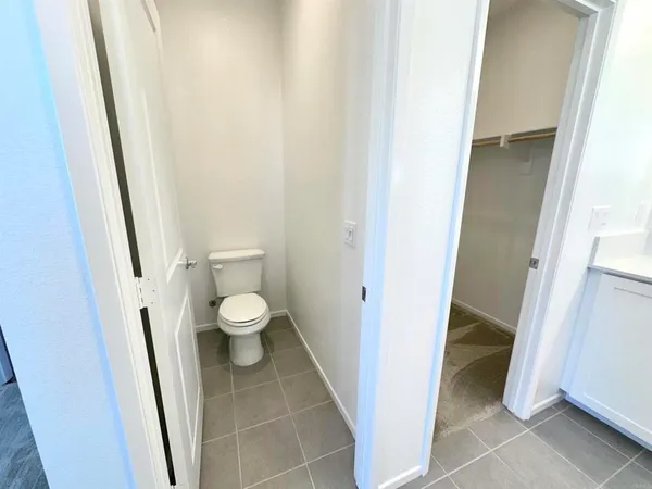 a bathroom with a granite countertop toilet and a sink