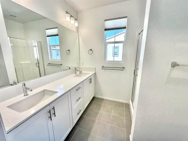 a bathroom with a double vanity sink a mirror and a bathtub
