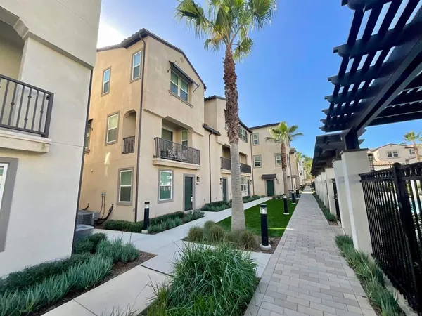 a front view of a house with a garden and trees