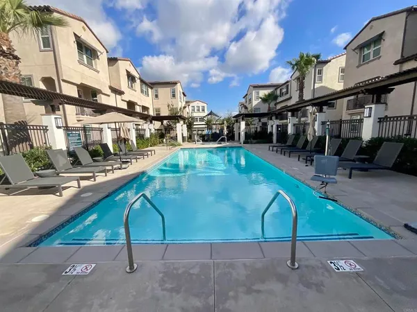 a view of a swimming pool with a bench and chairs