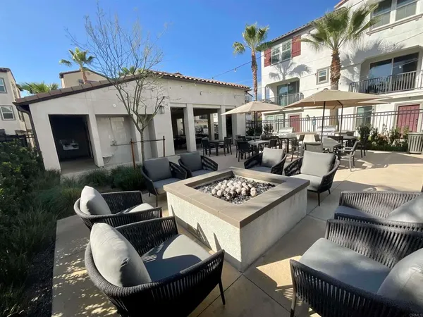 a view of a patio with couches table and chairs and potted plants