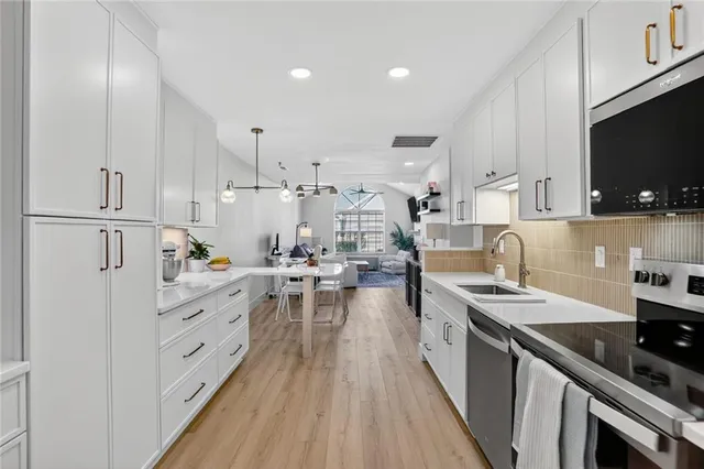 a kitchen with white cabinets sink and stainless steel appliances