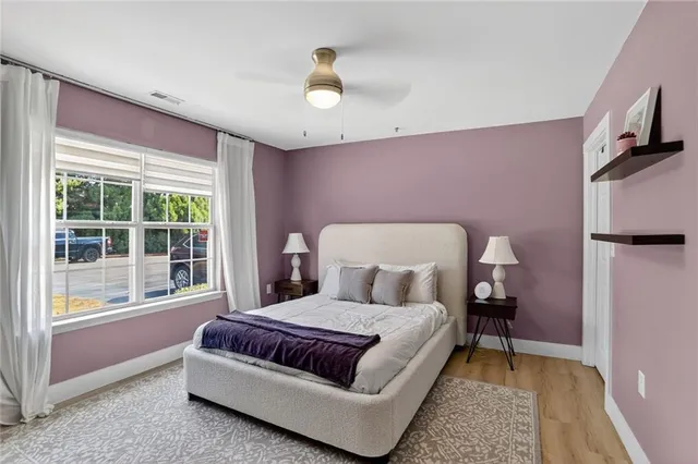 a bedroom with a bed lamp and a large window