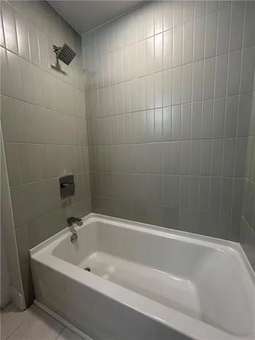 a white bath tub sitting next to a white sink and vanity