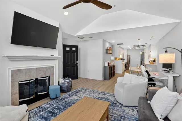 a living room with furniture a flat screen tv and a fireplace