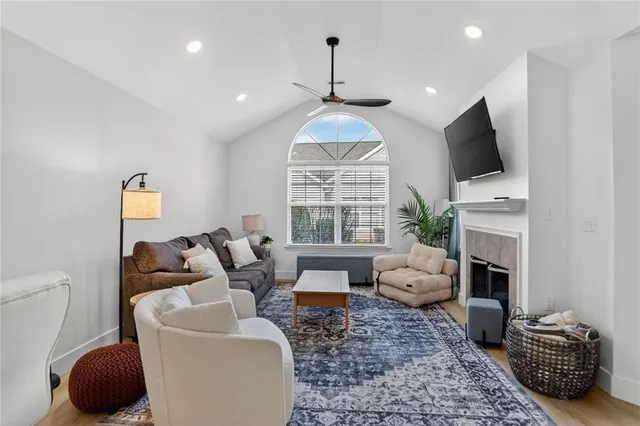 a living room with furniture a fireplace and a flat screen tv