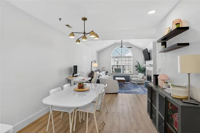 a view of a dining room with furniture a chandelier and wooden floor