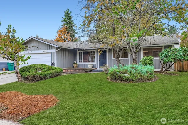 a view of a house with a yard and potted plants