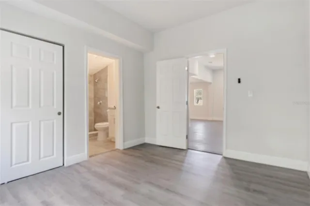 a view of empty room with wooden floor