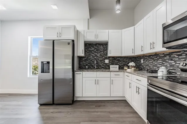 a kitchen with stainless steel appliances a refrigerator sink and microwave