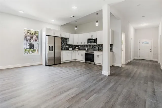 a kitchen with stainless steel appliances a refrigerator and wooden floor