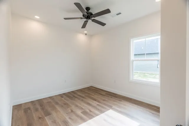 a view of empty room with ceiling fan